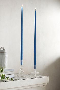 two blue candles sitting on top of a table