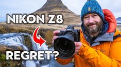 a man holding up a camera in front of a waterfall with the words nikn z8