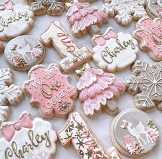 some decorated cookies are laying on a white tablecloth with snowflakes and christmas trees