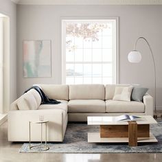 a living room filled with furniture and a large white couch in front of a window