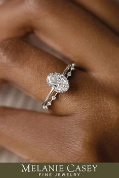 a woman's hand with a diamond ring on her left hand and the words melanie casey fine jewelry