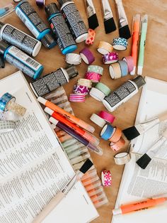 many different types of crafting supplies are laid out on a table next to an open book