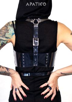 The Rogue underbust vest harness puts a futuristic spin on classic steampunk harness styles. Two straps buckle in front just underneath the bust/chest. The shoulder straps meet at the back and adjust with one vertical strap and buckle. Perfect for layering.Silver-toned nickel plated steel hardware.Shown in clear PVC. Also available in leather and vegan leather. All pieces are MADE TO ORDER, standard sizes XS-4XL. If your measurements fall outside these standards or you are unsure of what size to Punk Party Harness With Belt, Punk Style Party Harness With Belt, Black Steampunk Corset Belt For Larp, Edgy Fitted Harness With Belt, Party Harness With Belt Loops In Black, Fitted Punk Harness For Alternative Fashion, Black Party Harness With Belt Loops, Edgy Strapped Harness With Belt, Gothic Harness For Cosplay