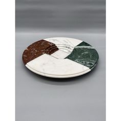 a marble plate with three different colors on the top and one is brown, white, green