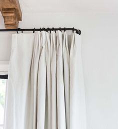 white curtains hanging on the side of a window