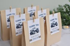 small bags with thank you cards attached to them sitting on a table next to a christmas tree