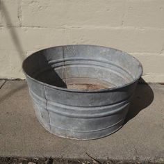 an old metal tub sitting on the sidewalk