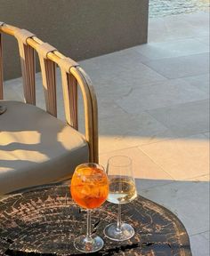 two glasses of wine sitting on top of a table next to a glass of water