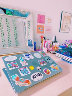 a laptop computer sitting on top of a desk covered in stickers and magnets