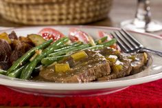 a white plate topped with steak and green beans