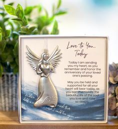 a card with an angel on it sitting next to a potted plant