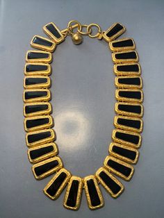 An AMAZING vintage 1980's gold choker collar necklace by Anne Klein. Featuring beautiful black enamel rectangular links surrounded in a rich ornate matte gold. A TRUE statement necklace! Avant garde mid century design. So incredibly EYE CATCHING. Perfect to wear for any occasion. Signed Anne Klein at the closure of the necklace Measurements: Total length of the necklace is 47.5cm. Width of a link is 3cm.  CONDITION: In ABOVE excellent vintage condition, The clasp is very secure. In amazing unwor Designer Black Metal Jewelry, Gold Rectangular Necklace For Evening, Rectangular Gold Necklace For Evening, Vintage Black Enamel Rectangular Jewelry, Vintage Rectangular Black Enamel Jewelry, Gold Enamel Necklace For Party, Gold Enamel Party Necklace, Designer Gold Jewelry With Black Enamel, Necklace Measurements