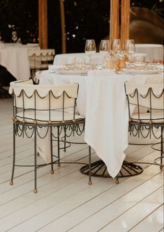 the table is set with white linens and place settings