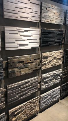 a wall with many different types of stone tiles on the walls and flooring in it