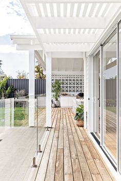 an outdoor patio with wooden flooring and white walls