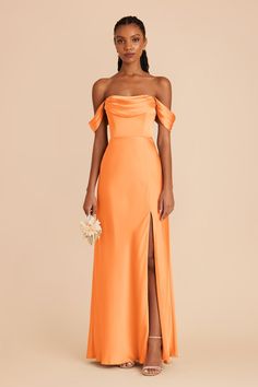 a woman wearing an orange dress with a slit down the side