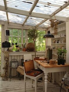 a room filled with lots of plants and pots on top of wooden shelves next to a window