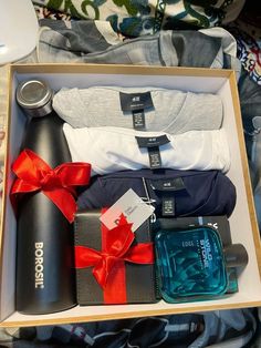 an open box containing several items such as socks, t - shirts and a bottle