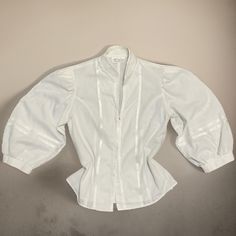 White gorgeous blouse with ruffle details on chest.  Very good condition.  It has a chic  style. Fits a modern S/M. Measurements Shoulders 36 CM  Bust 88 cm Sleeve length 45 cm  Length 53 cm Waist 80 cm  Everything is measured flat. SIZE on label 38 very good condition Pirate White Shirt, Long Sleeve Broderie Anglaise Top For Work, Formal Top With Lantern Gathered Sleeves, Classic Fitted Puff Sleeve Office Top, Classic Fitted Shirt With Puff Sleeves, Classic Fitted Puff Sleeve Top For Office, Fitted Shirt With Ruffled Collar For Daywear, Elegant Puff Sleeve Top For Daywear, White Blouson Sleeve Button-up Blouse