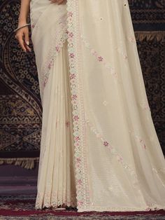 Introducing an exquisite off-white georgette saree that epitomizes elegance and grace, perfect for weddings, festivals, parties, and other special occasions. This beautiful saree is meticulously crafted from high-quality silk georgette fabric, combining the softness of silk with the lightweight and flowy texture of georgette. The off-white hue adds a touch of sophistication, making it a versatile addition to your ethnic wardrobe.
The saree is adorned with intricate sequin work, which shimmers de Elegant White Pre-draped Saree For Eid, White Pre-draped Saree With Resham Embroidery For Wedding, Elegant White Pre-draped Saree With Pallu, Festive White Pre-draped Saree With Cutdana, White Pre-draped Saree With Zari Work For Eid, Elegant White Georgette Pre-draped Saree, Elegant White Pre-draped Saree With Sheer Dupatta, Cream Saree With Intricate Embroidery For Festivals, Festive Cream Georgette Pre-draped Saree