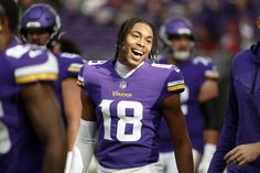 a football player with dreadlocks walking on the field