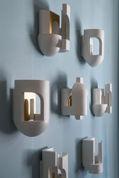 there are many different shapes and sizes of wall sconces on this blue wall