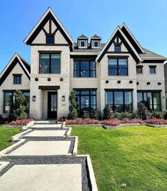 a large house with lots of windows and stone walkways leading to the front door