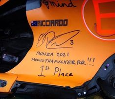 an orange race car with autographs on it