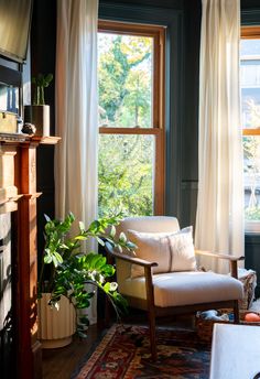 a living room filled with furniture and a fire place next to a window covered in curtains