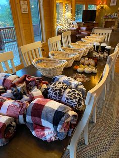 a table with many blankets on top of it and some chairs in front of them