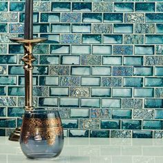 a candle holder sitting on top of a counter next to a blue tile backsplash