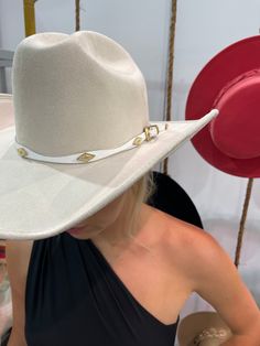 A timeless and on trend cowboy hat that’s crafted in a ivory faux suede with a coordinating band wrapped around. Meet the Dolly Cowboy Hat. The crown is stiffened and shaped into a clean and ridged design. Hand made by artisans, incredible quality, faux suede, lined with satin underneath. The best part? It's super structured with an elastic band on the inside that will fit EVERYONE. THE HAT:-Cowboy style hat, faux suede-Stiff brim with elastic hat band on the inside-- OMG YES-Gorgeous ivory-Hold Cream Cowboy Hat, Chic Adjustable White Hat Band, Chic White Adjustable Hat Bands, Luxury High Crown Adjustable Hat Bands, Luxury White Fedora, Chic White Hat Bands For Kentucky Derby, Luxury Fedora For Rodeo, Luxury White Fedora For Kentucky Derby, Luxury White Fedora Hat