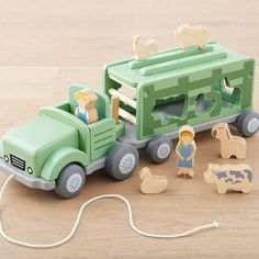 a green toy truck with people and animals