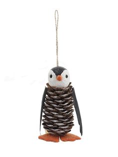 a penguin ornament hanging from a rope with pine cones on it's back