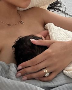 a woman is breastfeeding while laying in bed