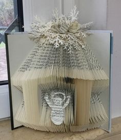 an open book in the shape of a house made out of books with pages folded into it