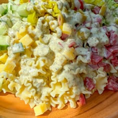 a wooden bowl filled with pasta salad on top of a table