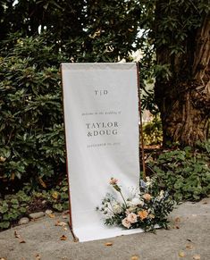 a wedding ceremony sign with flowers on it