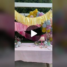 a pink and yellow table with balloons on it