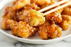 a white plate topped with chicken and chopsticks