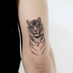 a small tiger tattoo on the arm