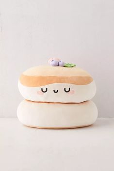 two stuffed animals sitting on top of each other in the shape of hamburgers with eyes closed