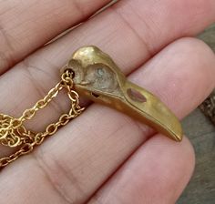 Beautiful details and delicate design make this Raven Skull Pendant very special. Antiqued gold skull dangles from gold plated chain. The subtle gold color of the bird skull and fine quality give this simple piece of jewelry an aged feel and a nice sturdiness you can feel. Truly one of my very favorite designs. A lovely pair coordinating earrings are available, as well. Bird Skulls are a favorite theme of mine and you will find many other pieces of jewelry at A Cheerful Nest featuring the skulls Gold Metal Necklace For Halloween, Adjustable Gold Jewelry For Halloween, Gold Skull Necklace For Halloween, Halloween Skull Shaped Gold Jewelry, Bronze Skull-shaped Jewelry Gift, Bronze Skull Jewelry For Gifts, Bronze Skull Jewelry Gift, Bird Skulls, Bird Skull Jewelry