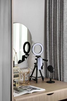 a desk with a mirror, camera and other items on it