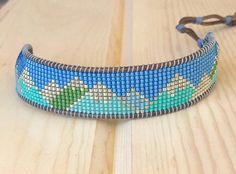 a blue beaded bracelet sitting on top of a wooden table