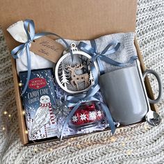 a christmas gift box with an ornament, mug and other items