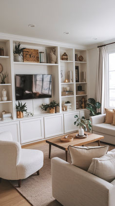 a living room filled with furniture and a flat screen tv mounted on a wall next to a window