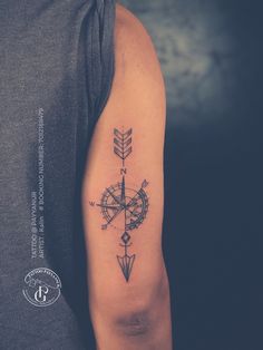 a man with a compass tattoo on his arm