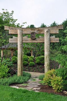 a stone path leading to a wooden structure in the middle of a lush green garden