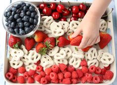 a tray filled with fruit and pretzels on top of a table